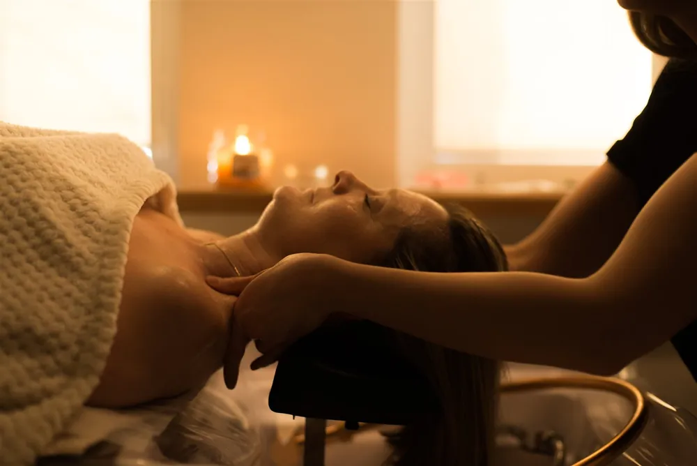 Masaż twarzy przy świecach na początku rytuału Head Spa